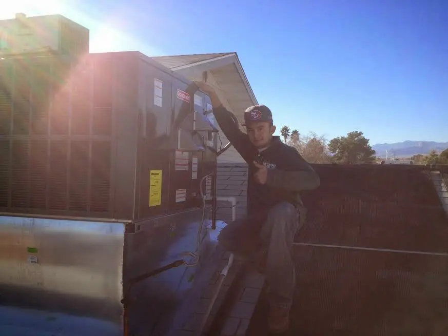 HVAC technician performing Air Duct Repair on a rooftop unit in Hartford