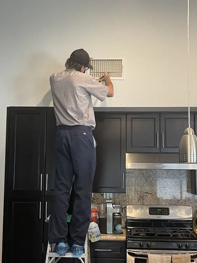 Technician inspecting an air vent during HVAC service in Hartford